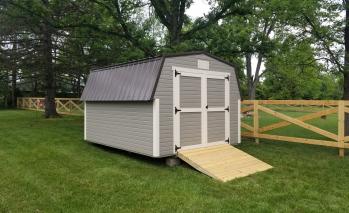 Gray Signature High Barn with white trim, double doors, a ramp, and dark gray roofing.